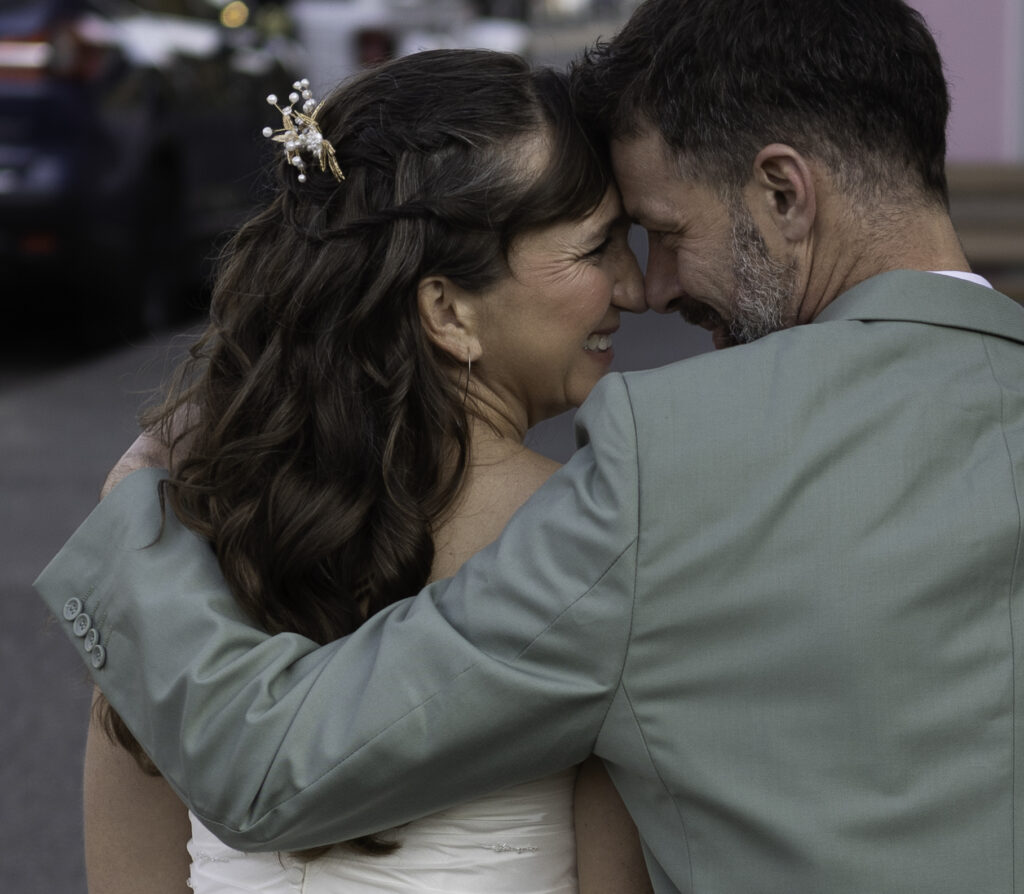 wedding couple sitting on bench nose to nose