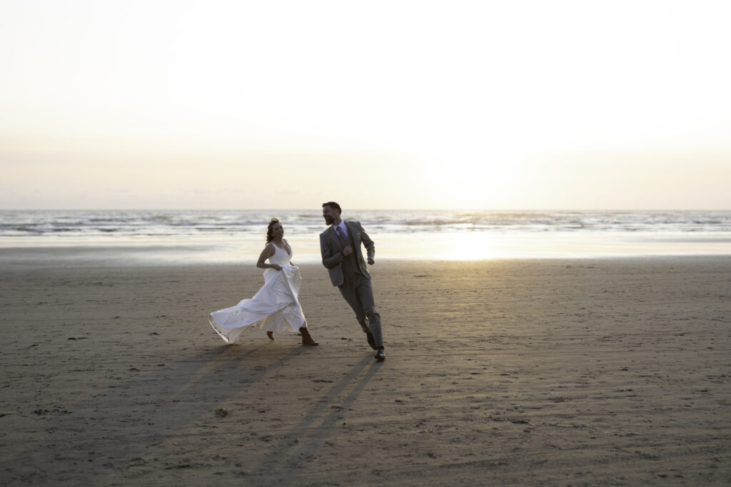 wedding couple play a vigorous game of tag on the beach 