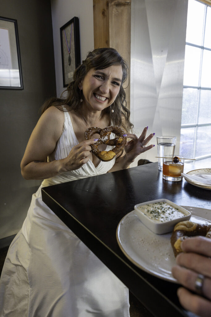 bride showing off pretzel in a silly way