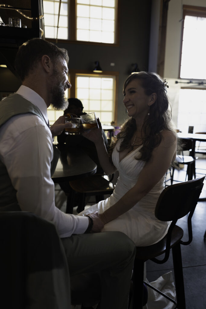 wedding couple at Pelican Brewery cheers with old fashinoned drinks at bar
