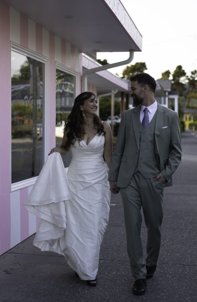 couple walks hand and hand down the charming streets of cannon beach oregon.