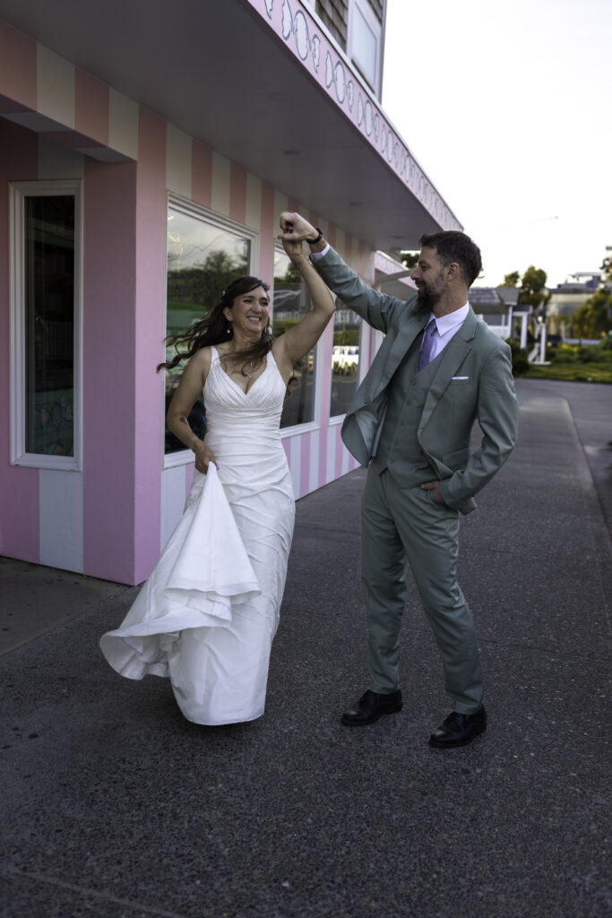 couple twirls in front of the candy shop in Cannon Beach