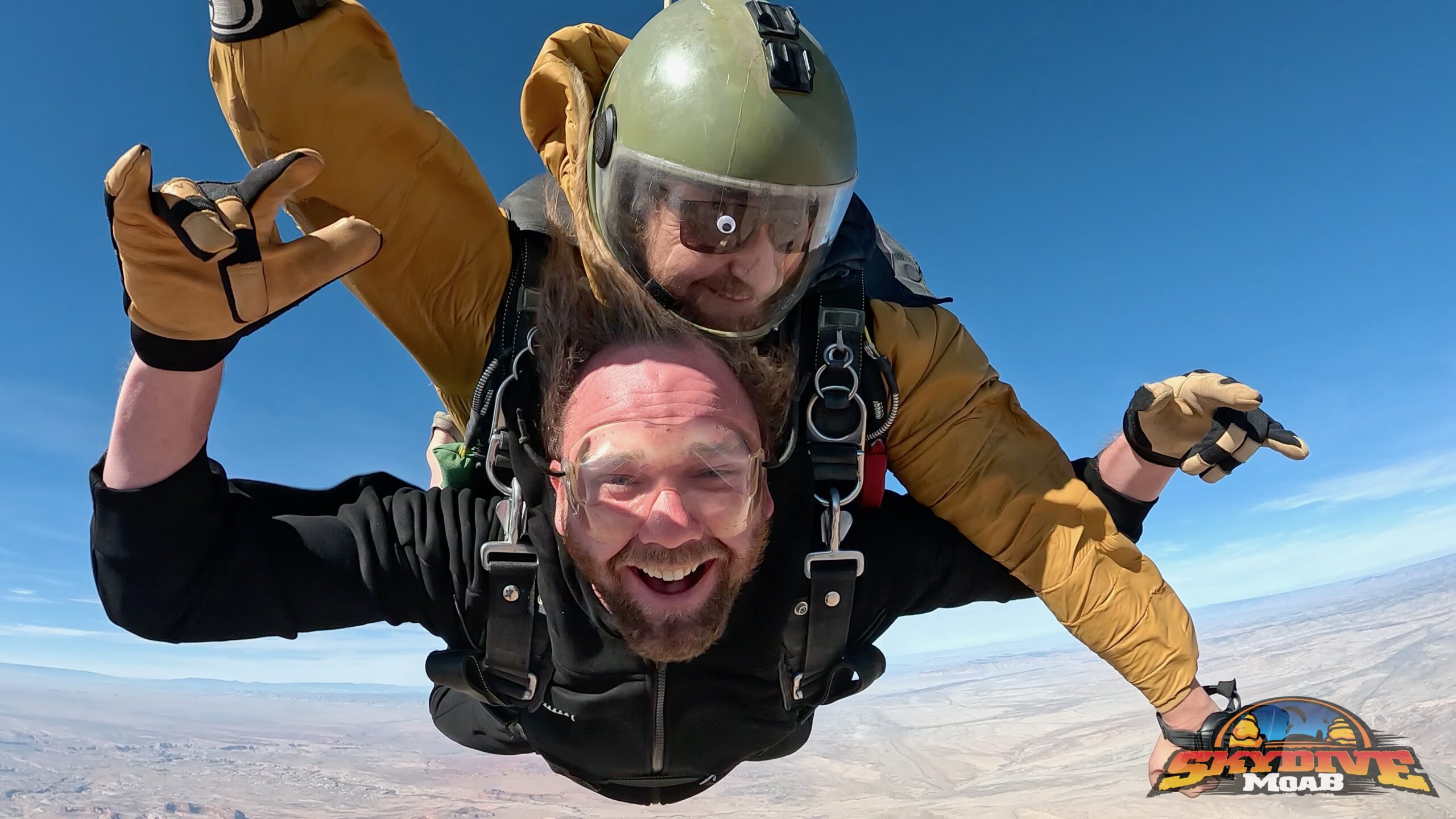groom skydiving tandem with instructor during their Moab elopement day