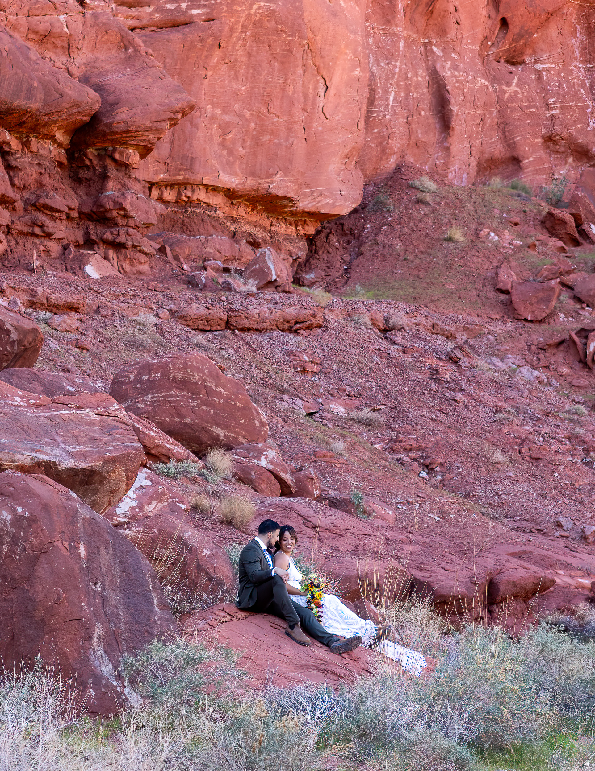 sitting and enjoying each others company with red rocks surrounding them. 
