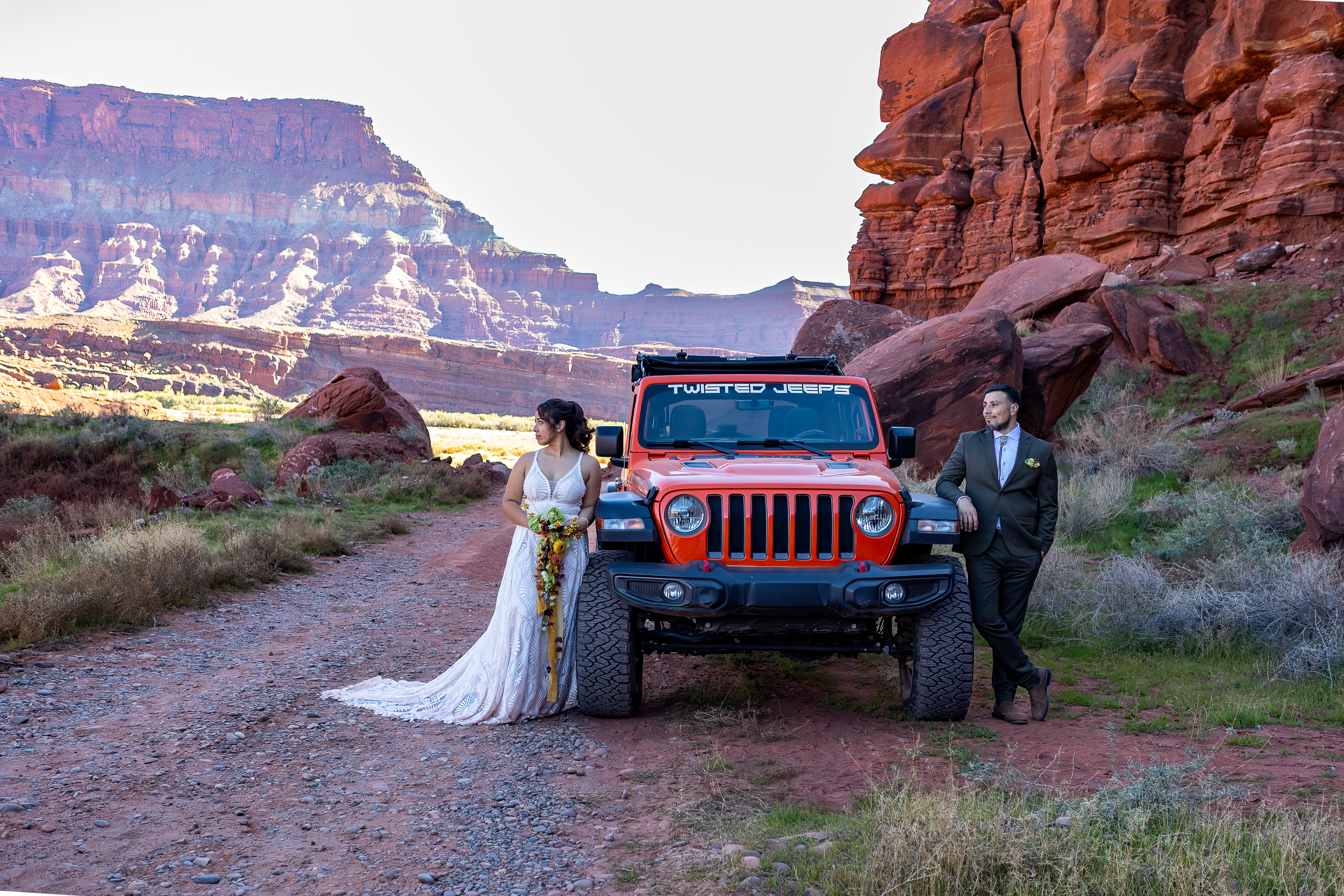 couple posing on either side of rental jeep