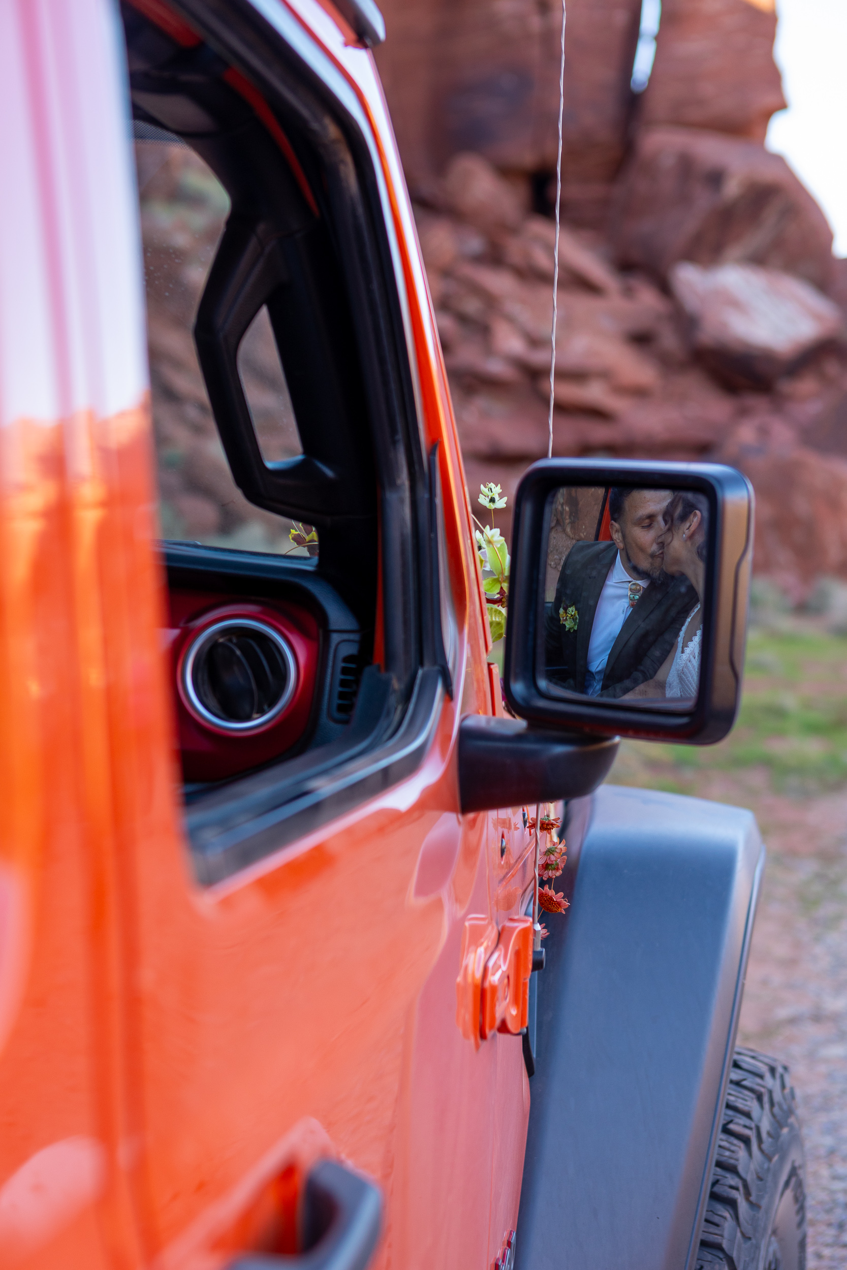 hugo and laura kiss in the reflection of the side mirror