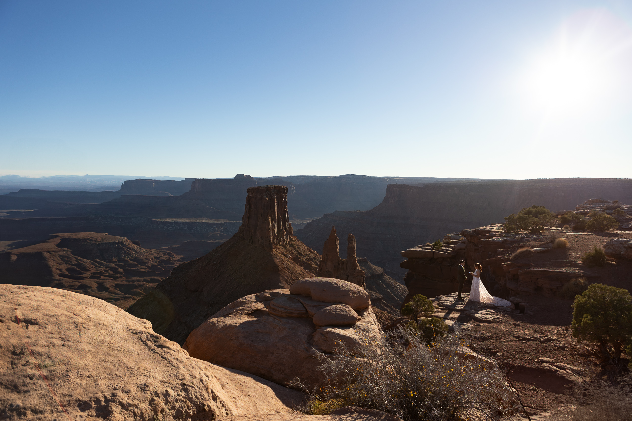 Laura and Hugo standing next to the cliffs edge saying their vows completely surrounded by red rocks and valleys