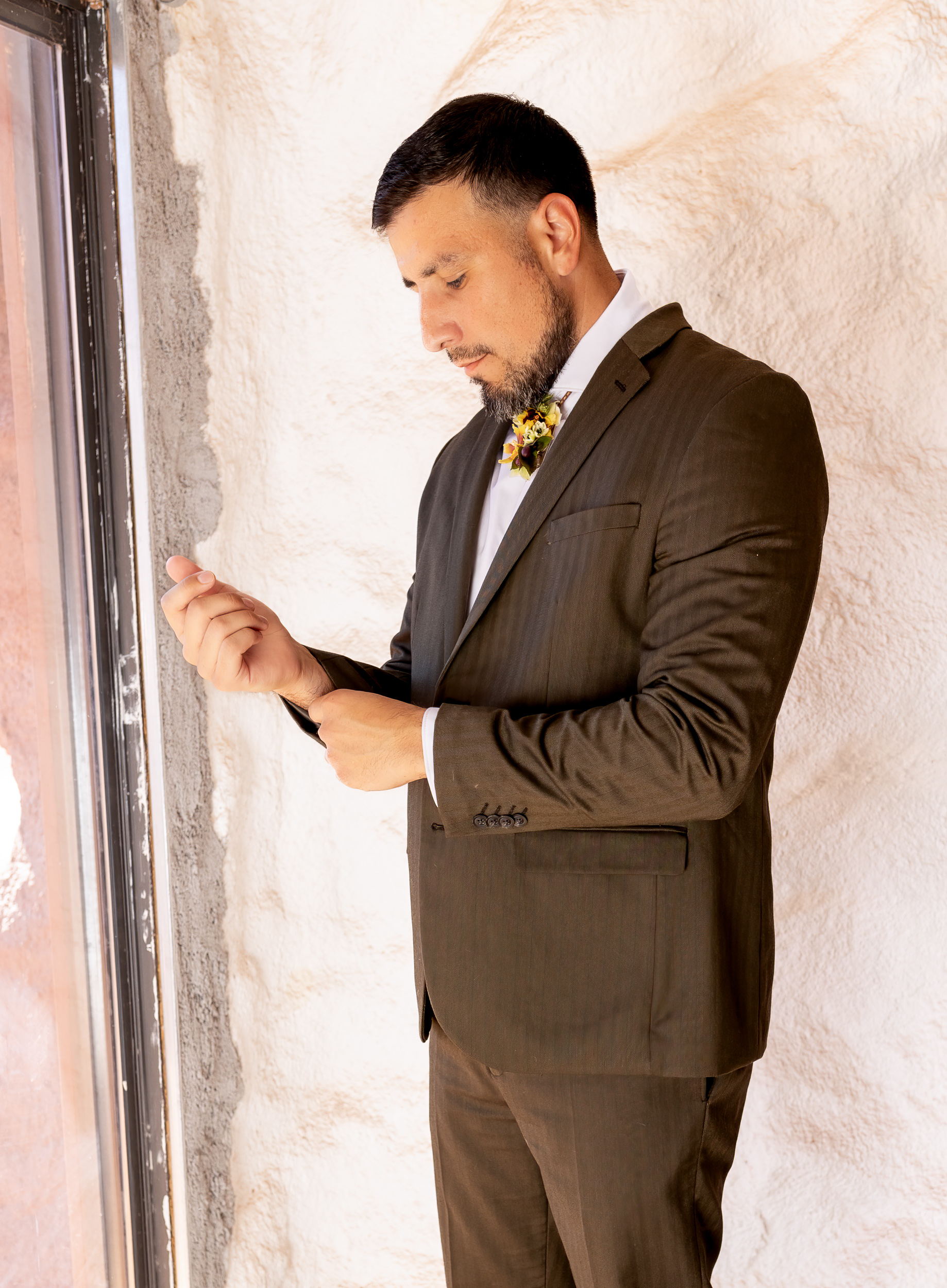 Hugo adjusting his sleeves of suit jacket