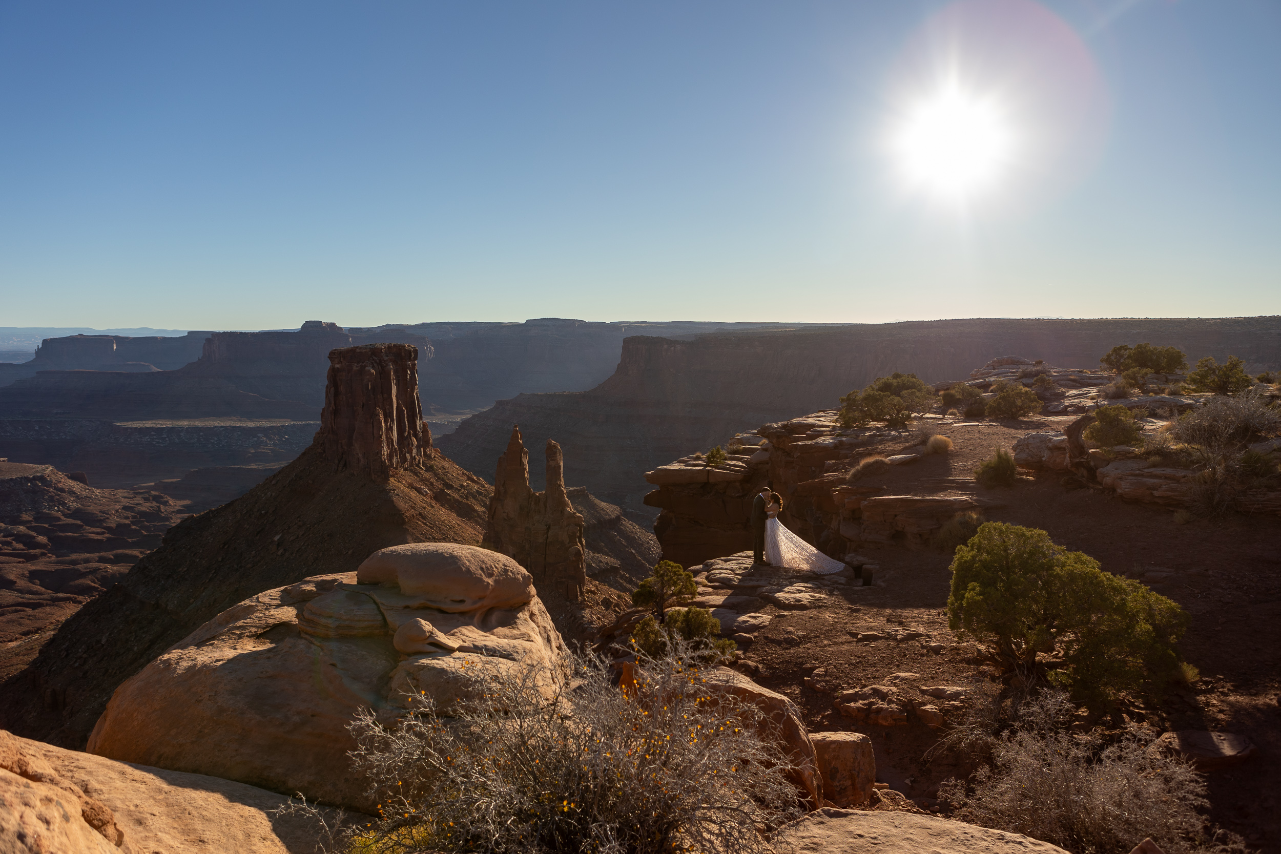 Laura and Hugo stand on the edge of a cliff in a secuded Moab BLM location while they say their vows