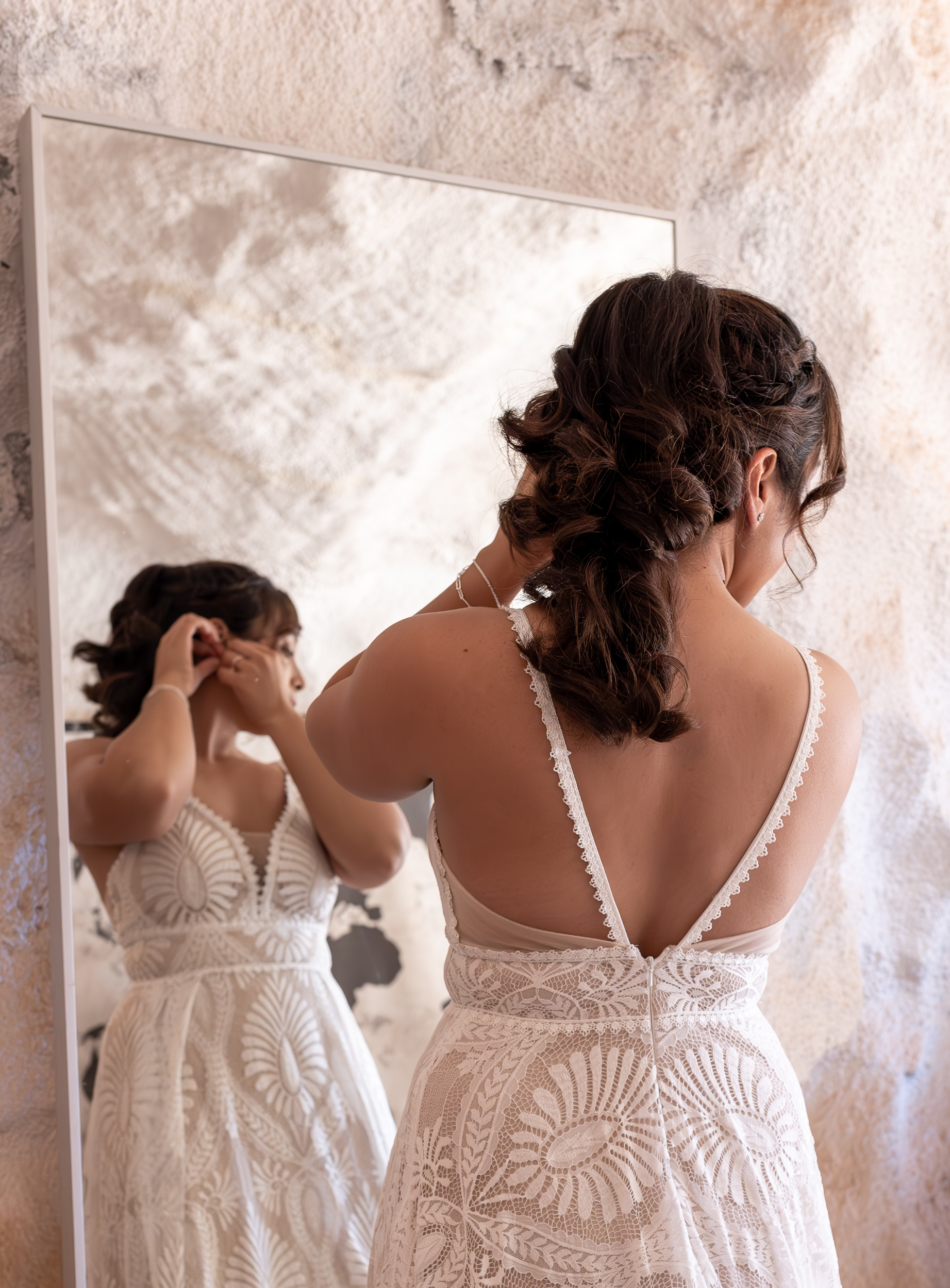 Laura in front of mirror adjusting earring