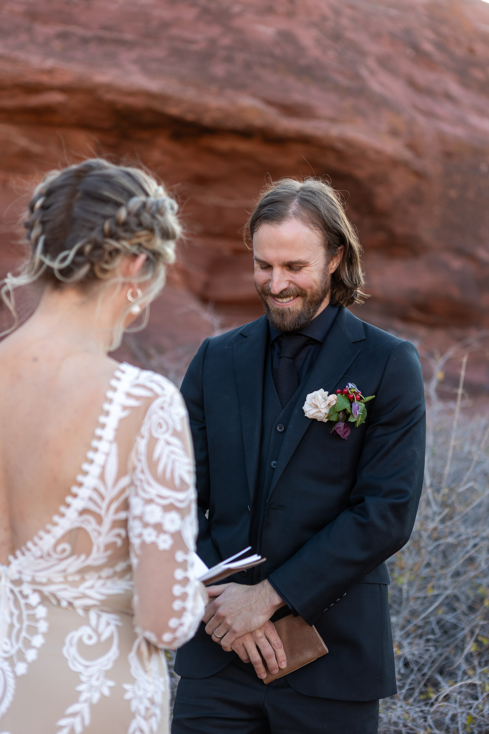 close up of grooms face while bride reads vows