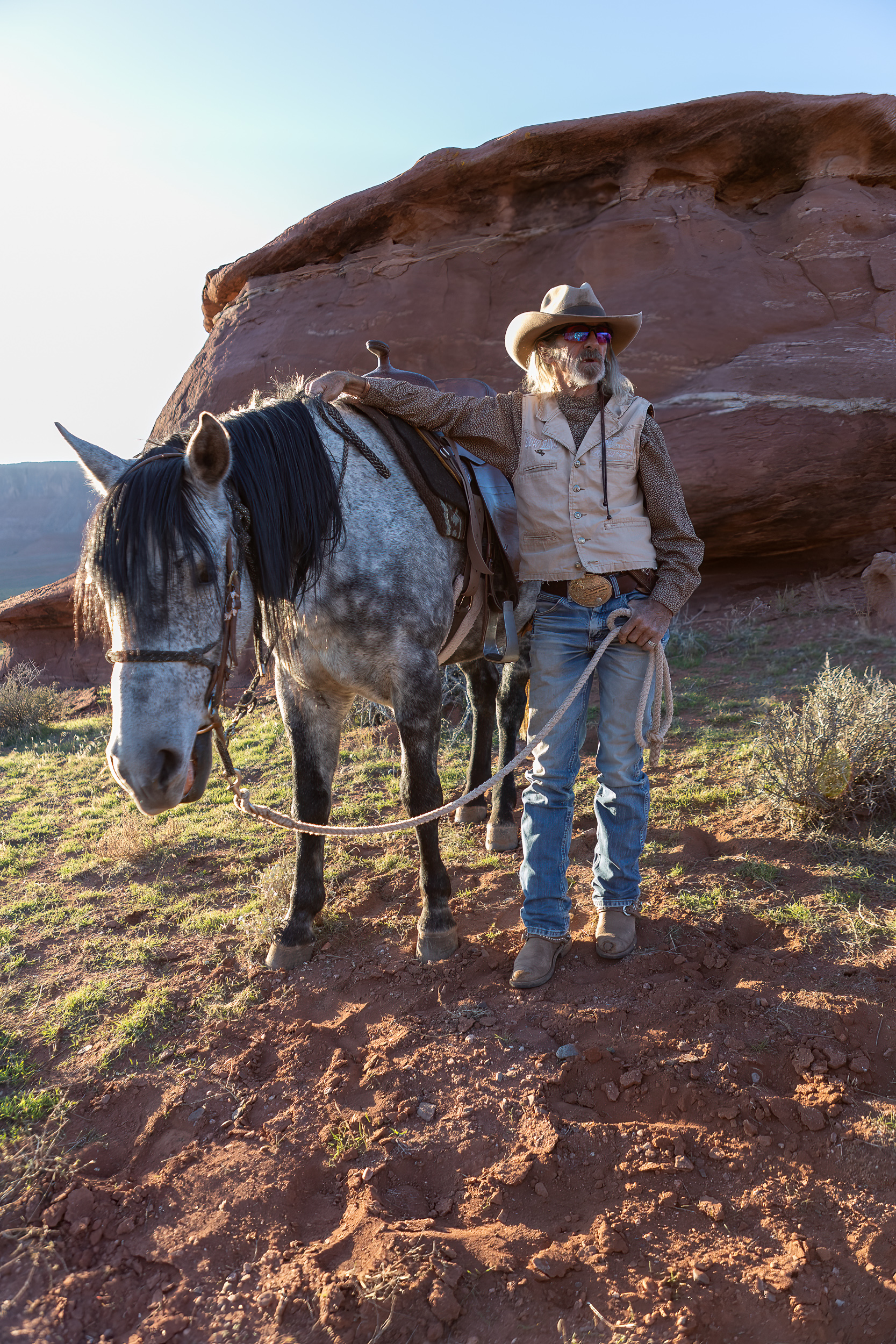 the rancher slow hand leaning against his horse sage