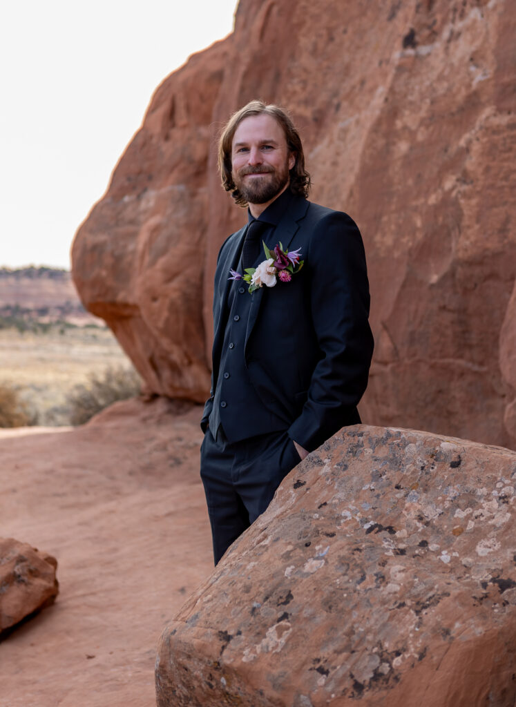 elliott standing behind a red rock