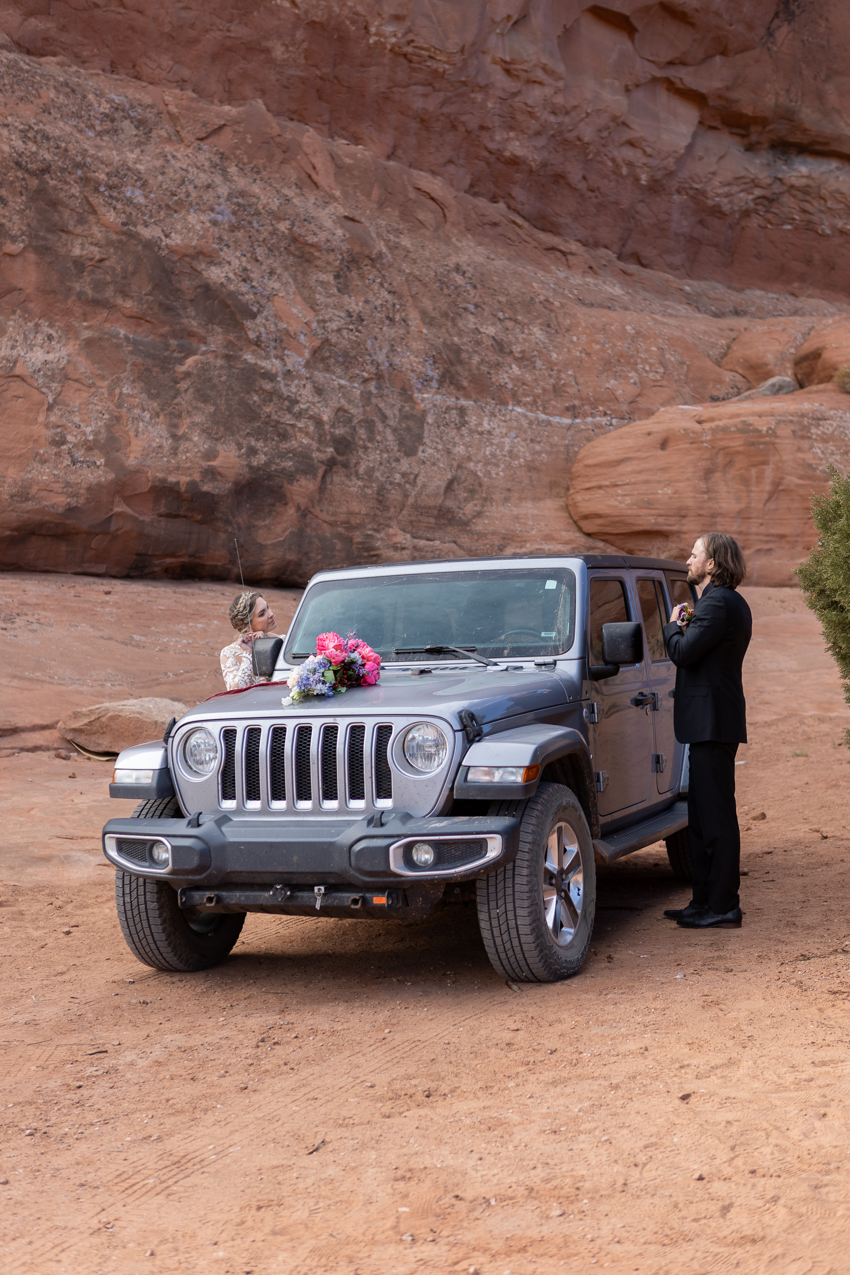 couple getting ready on either side of their jeep