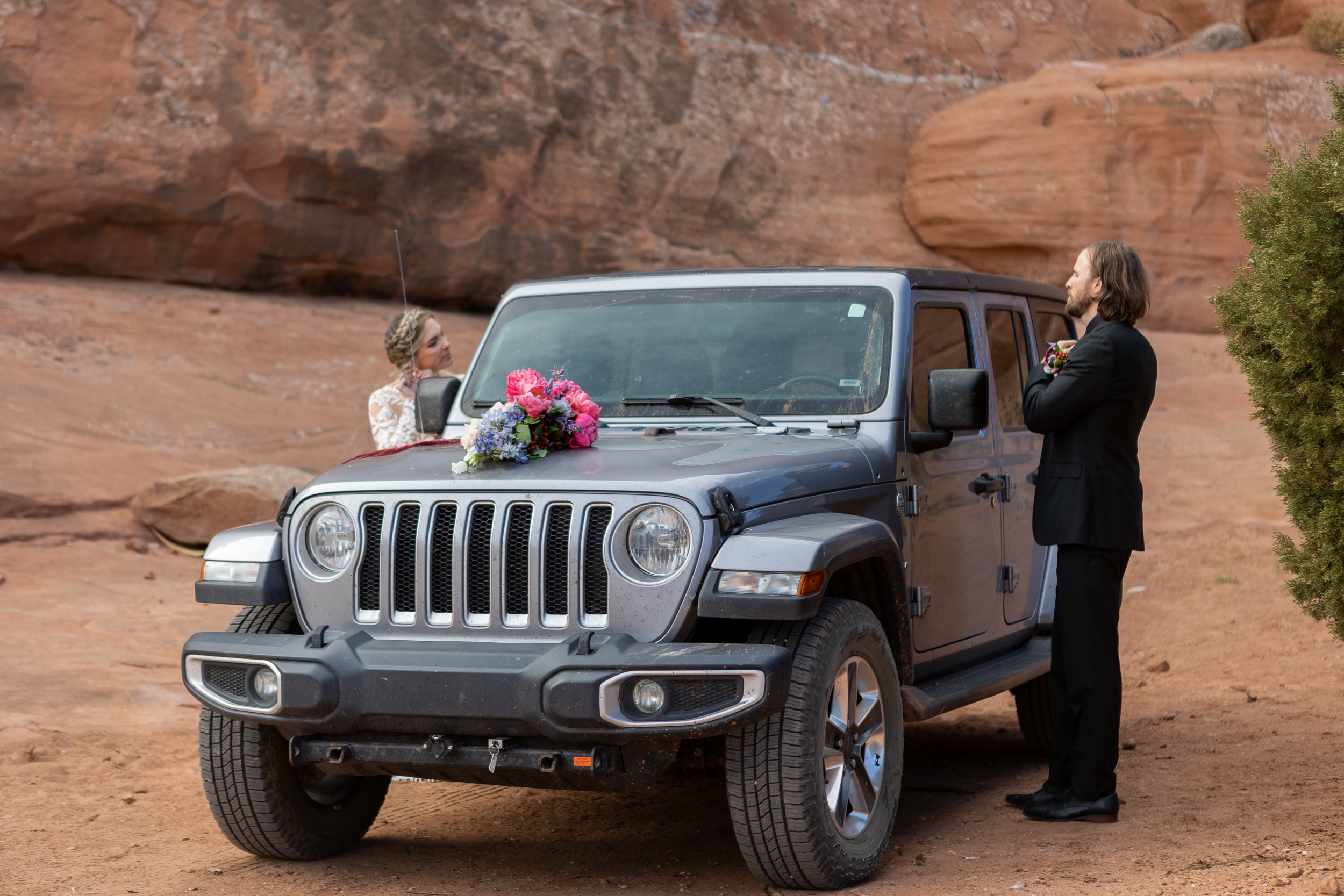 couple getting ready on either side of their jeep