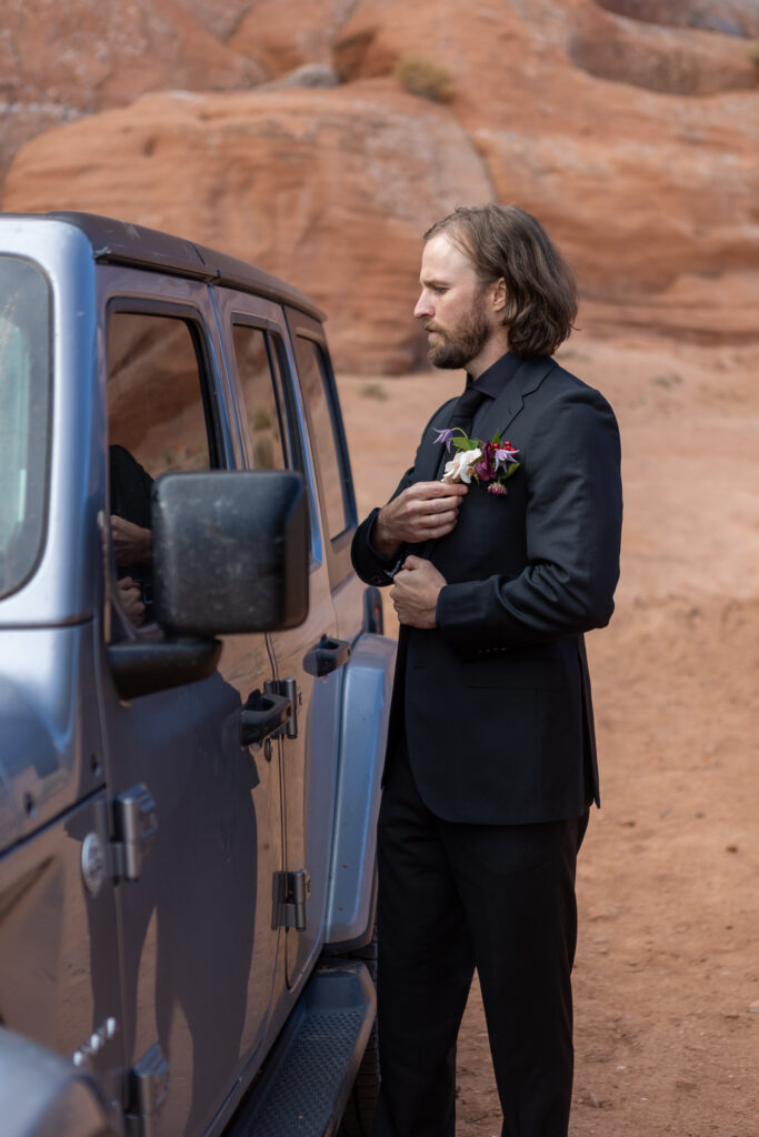 adjusting his boutinairre in jeep window