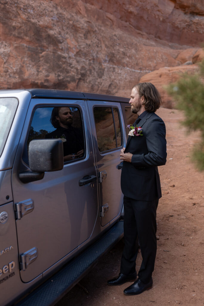 adjusting jacket while looking at jeep
