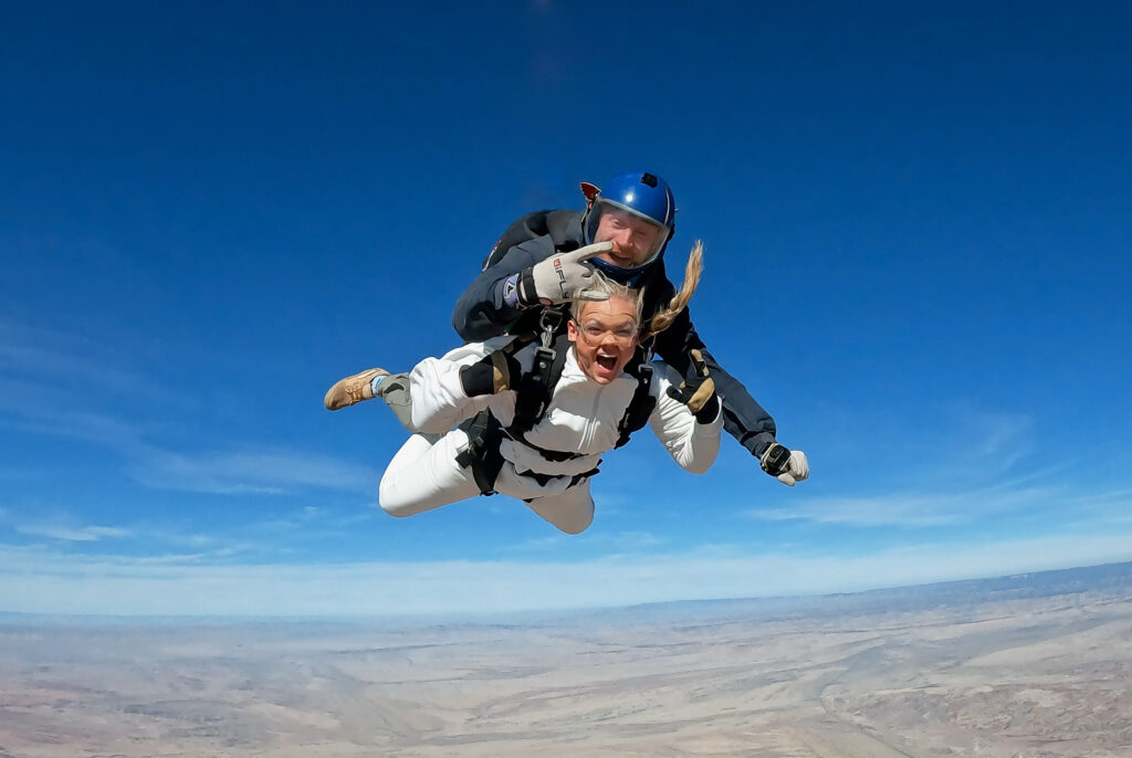 Bride skydiving over the red rock landscape of Moab, Utah during an adventurous elopement experience