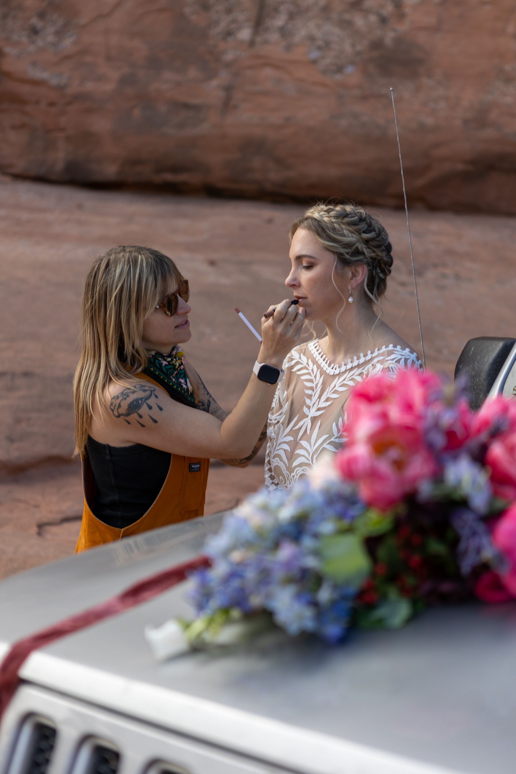 makeup artist adjusting brides makeup near jeep
