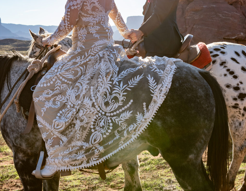 Moab elopement activity on horseback while holding hands