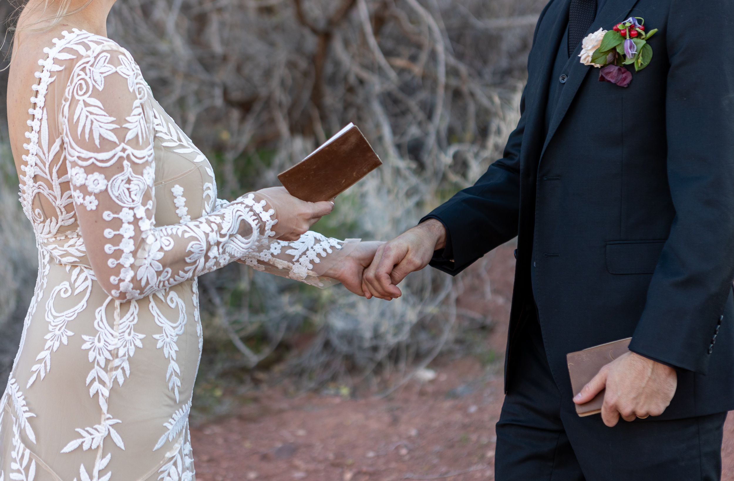 close up of bride reading vows while holding grooms hand