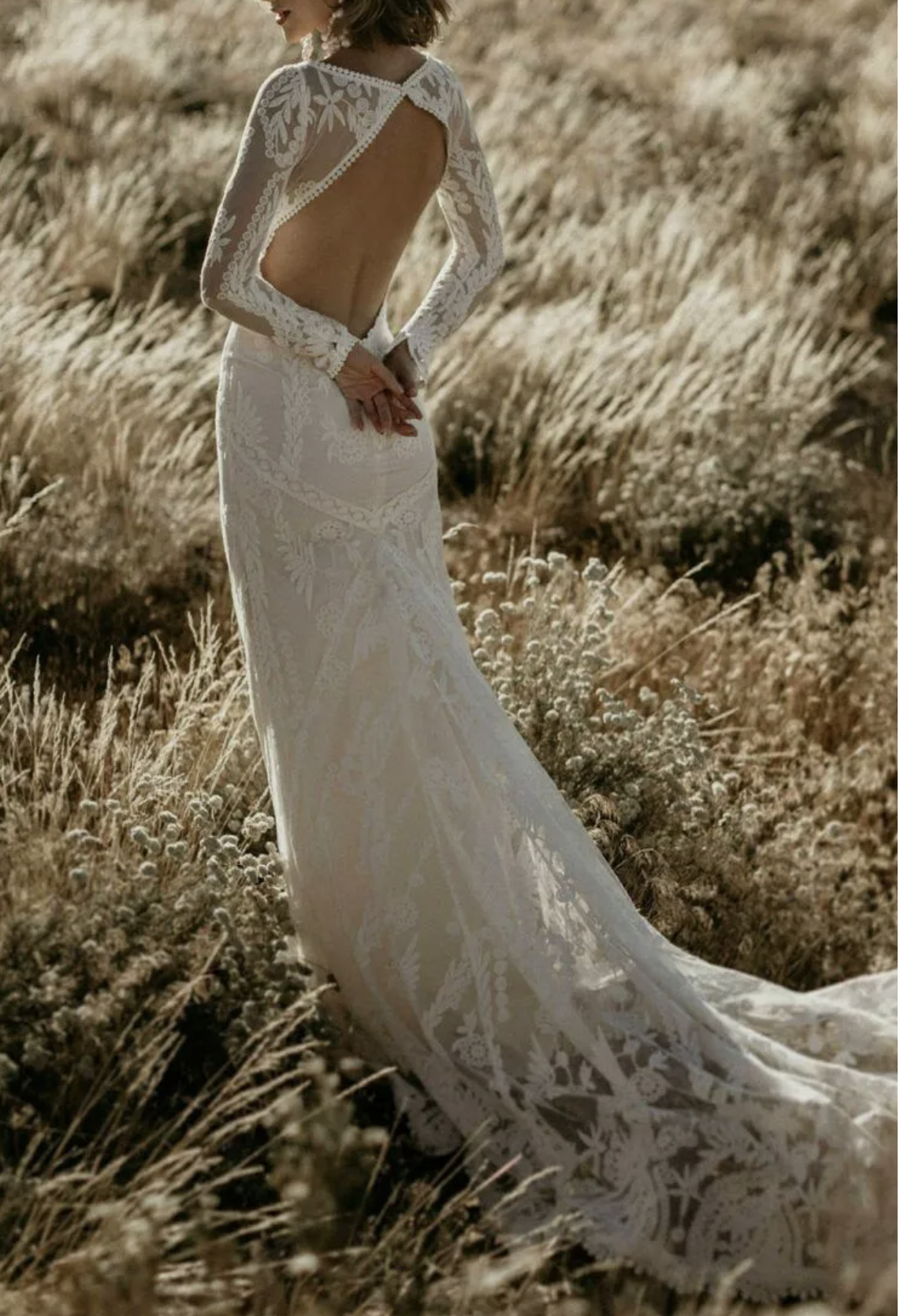 Bride wearing lace long sleeve boho elopement dress in Moab desert wind