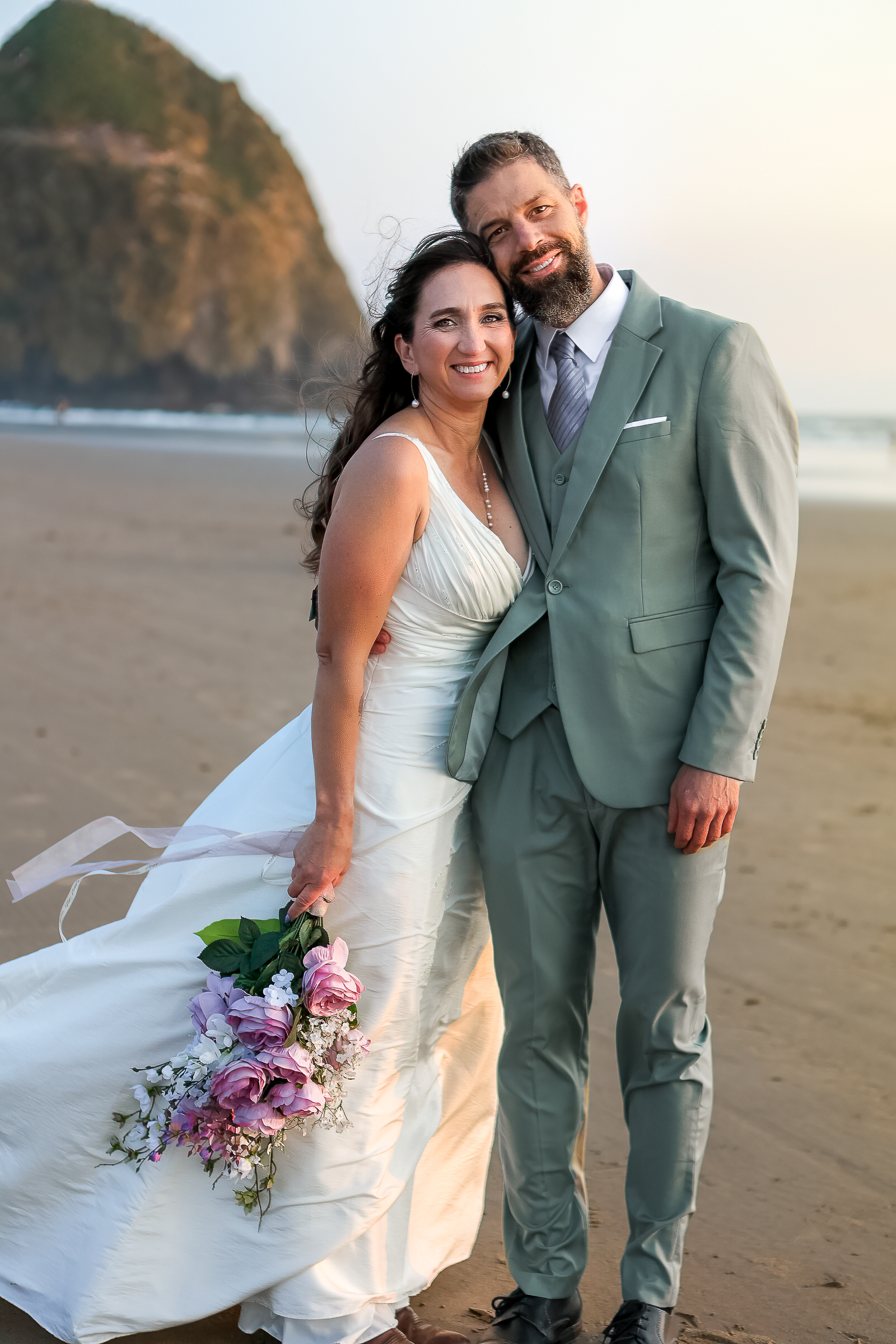 Romantic sunset portraits with waves crashing behind the couple at Cannon Beach