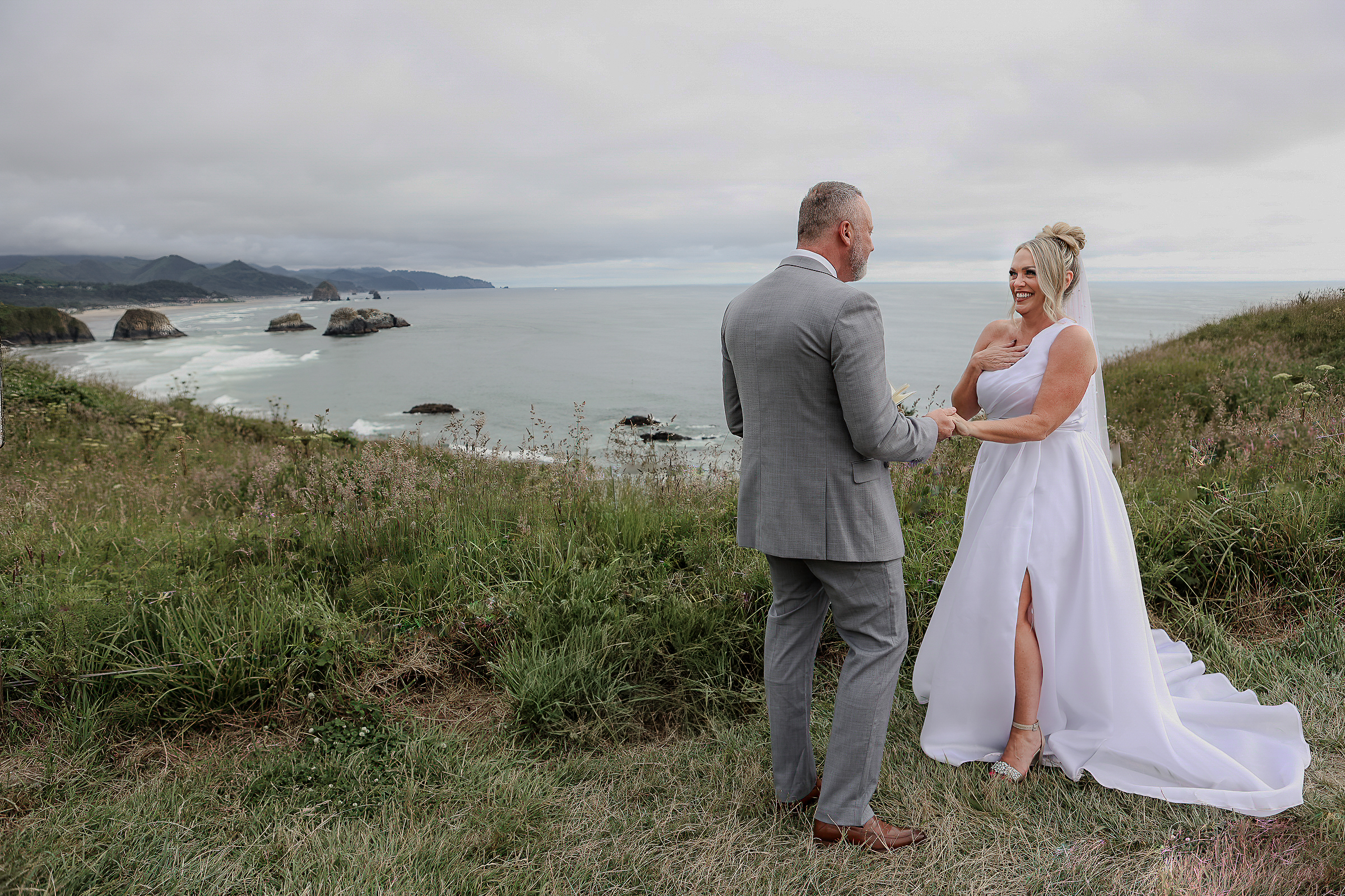 Couple sharing a quiet moment  while saying vows on a cliff overlooking the ocean at Ecola State Park.