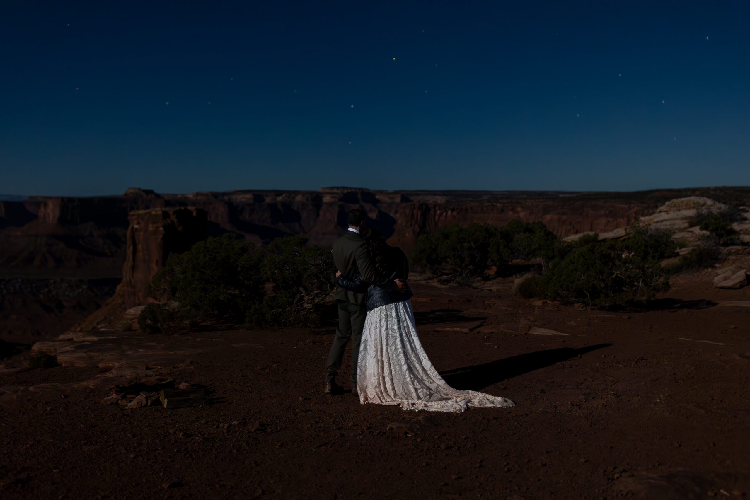 Wide shot of desert cliffs under stars after elopement