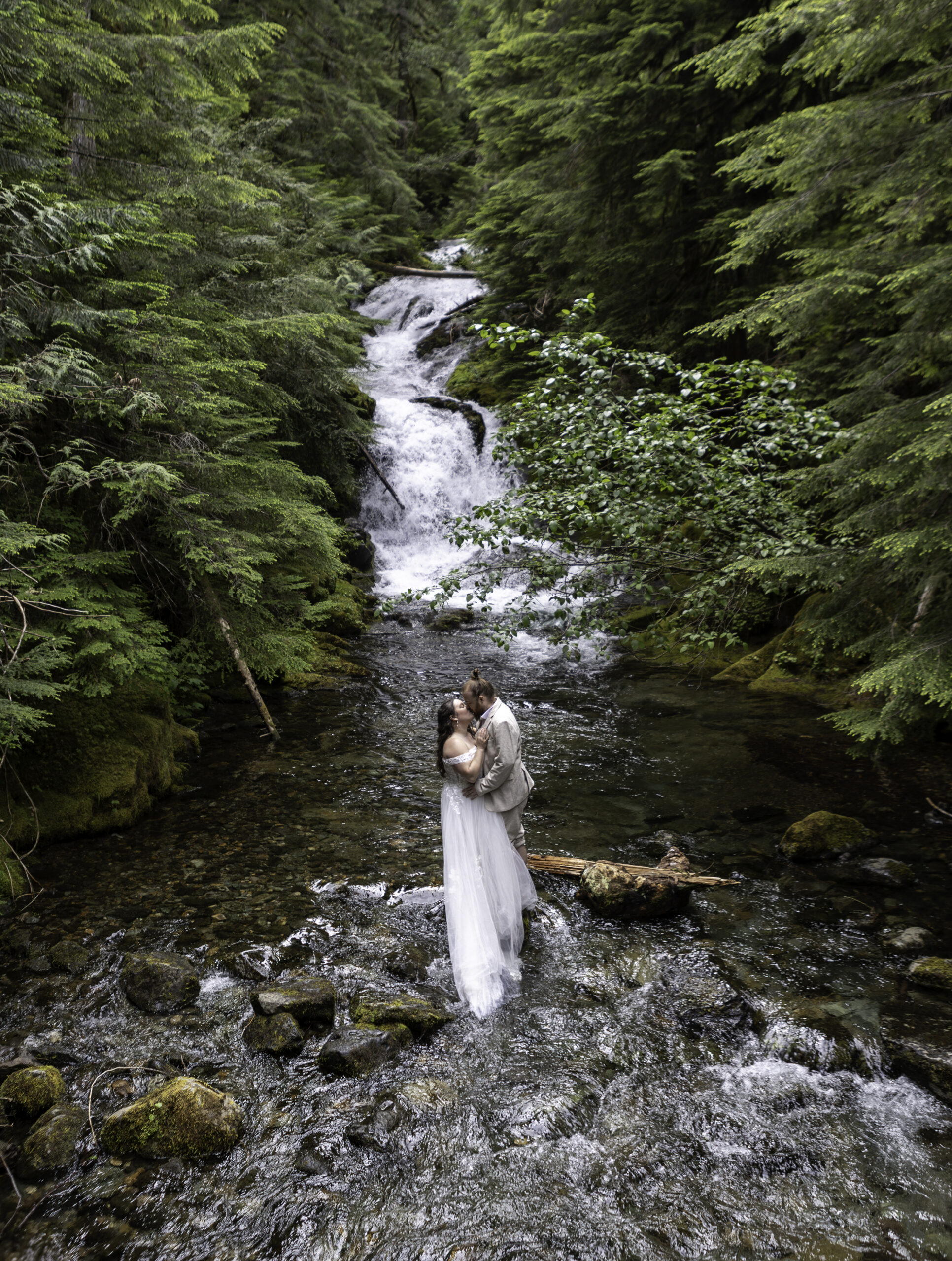 couple kissing in the water under a waterfall. PNW Summer Activity idea. 